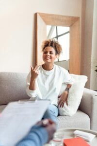 Smiling woman in a therapy session on a comfortable sofa.